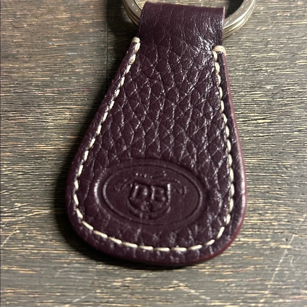 Dooney & Bourke leather key fob, featuring‎ an embossed logo dark plum